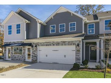 Attractive exterior of a two-story townhome with stone accents and a two-car garage at 718 Apple Churn Dr, Fuquay Varina, NC 27526