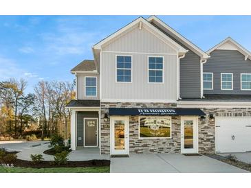 Two-story townhome with stone accents and a covered porch at 720 Apple Churn Dr, Fuquay Varina, NC 27526