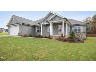 Gray house with white columns, two-car garage, and landscaped lawn at 33 Winterwood Dr, Benson, NC 27504