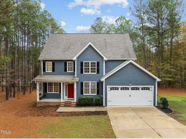 Two-story house with gray siding, white garage door, and red front door at 5600 Thornburg Dr, Wake Forest, NC 27587