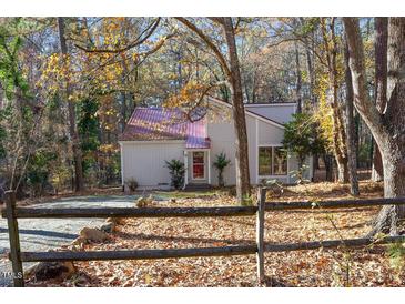 House exterior featuring a metal roof and wood siding, nestled in a wooded setting at 144 Loblolly Ln, Chapel Hill, NC 27516