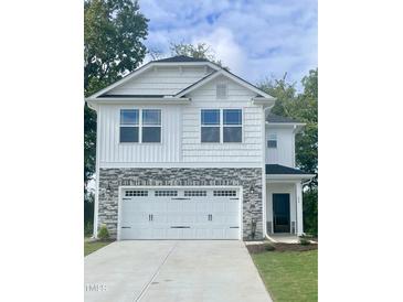 Two-story house with white siding, stone accents, and a two-car garage at 251 Hopewell Branch Ct, Smithfield, NC 27577