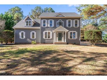 Two story gray house with white shutters, green door and large yard at 3128 Gold Dust Ln, Willow Springs, NC 27592