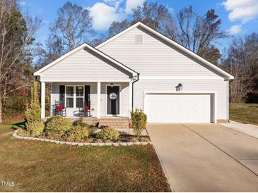 Gray house with white garage and rocking chairs on the porch at 50 Timber Ct, Spring Hope, NC 27882