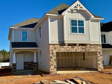 Two-story house with beige vinyl siding, stone accents, and a two-car garage at 63 Nimble Way # 183, Clayton, NC 27520