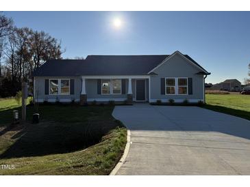 Gray house with a concrete driveway and landscaping at 198 Pate Landing Dr, Selma, NC 27576