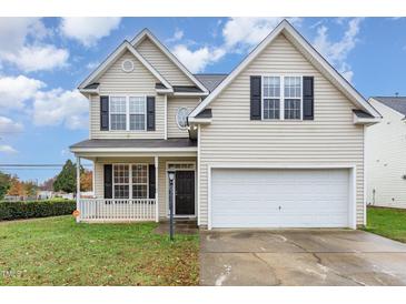 Two-story house with beige siding, a white garage door, and a well-maintained lawn at 2124 Star Sapphire Dr, Raleigh, NC 27610
