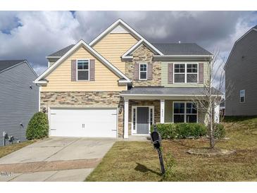 Two-story house with stone accents and a two-car garage at 3911 Massey Wood Trl, Raleigh, NC 27616