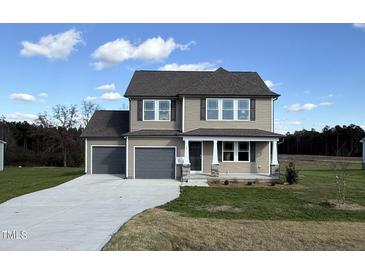 Two-story house with gray siding, gray double garage doors, and a stone accent at 36 Holly Grove Ln, Lillington, NC 27546