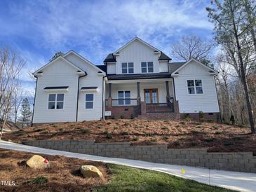 Two-story farmhouse style home with white siding and landscaping at 37 Sweet Meadow Ln, Pittsboro, NC 27312