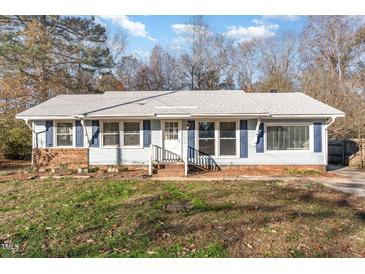 Ranch style home with brick and light blue vinyl siding, steps to the front door and landscaping at 3015 E Brinkley Dr, Spring Lake, NC 28390