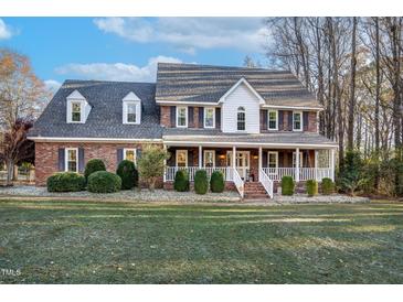 Brick two-story house with a large front porch and well-maintained lawn at 4027 Green Forest Ct, Rocky Mount, NC 27804