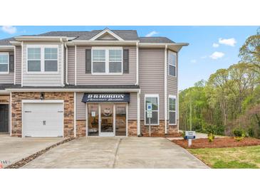 Two-story townhome with gray siding, stone accents, and a two-car garage at 1813 Hinesley Dr, Durham, NC 27703