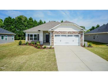 New construction home with stone accents, two-car garage, and landscaped lawn at 51 Sunburst Ct, Fuquay Varina, NC 27526