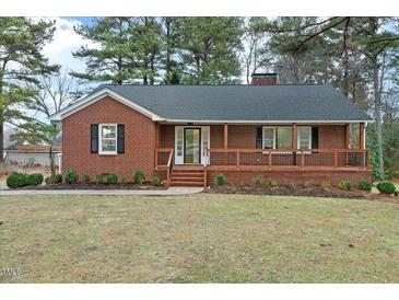 Brick ranch house with a large front porch and landscaped yard at 303 Forest Rd, Oxford, NC 27565