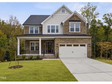Two-story house with stone accents and a three-car garage at 3177 Armeria Dr, Apex, NC 27502
