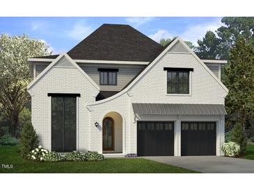 Two-story home with white brick exterior, black garage doors, and landscaping at 307 S Elm St, Apex, NC 27502