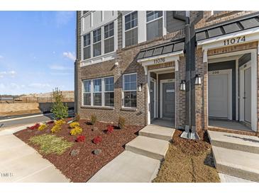 Brick front exterior of townhome with landscaped garden at 1235 Shaw View Alley # 201, Raleigh, NC 27601