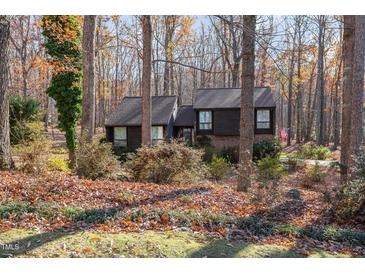 Two-story house with dark siding, brick accents, and a wooded backdrop at 329 N Ridge Cir, Roxboro, NC 27574