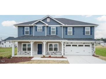 Two-story house with blue siding, stone accents, and a covered porch at 68 Northwood Dr, Fuquay Varina, NC 27526