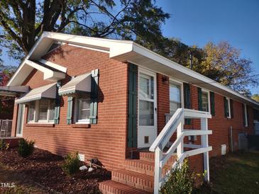 Brick house with green shutters, white steps, and landscaping at 120 W Academy St, Wendell, NC 27591