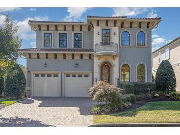 Two-story home with gray siding, two-car garage, and landscaped yard at 15 Treviso Pl, Durham, NC 27707