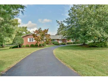 Brick ranch home with long driveway, mature trees, and landscaped yard at 304 Homestead Rd. Rd, Chapel Hill, NC 27516