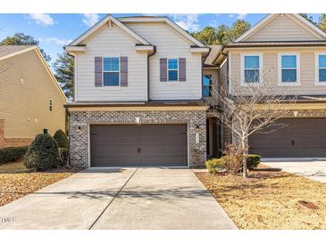 Two-story townhome with brick and siding exterior, attached garage, and landscaping at 154 Alamosa Pl, Cary, NC 27519