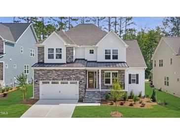 Charming two-story home with a stone and siding exterior, front porch, and attached garage at 3189 Armeria Dr, Apex, NC 27502