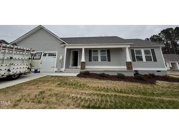 New construction home with gray siding, white trim, and covered front porch at 193 Magnolia Run Way, Benson, NC 27504