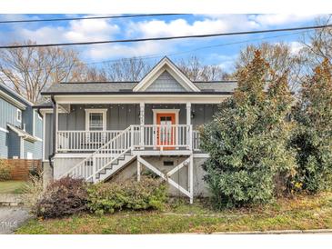 Charming gray home with orange door and inviting front porch at 725 S State St, Raleigh, NC 27601