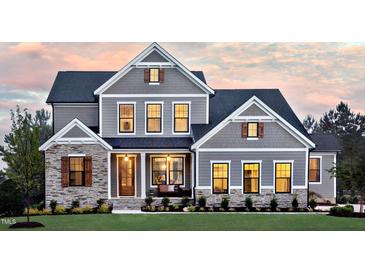 Two-story home with gray siding, stone accents, and a landscaped lawn at 259 August Trce Dr, Pittsboro, NC 27312