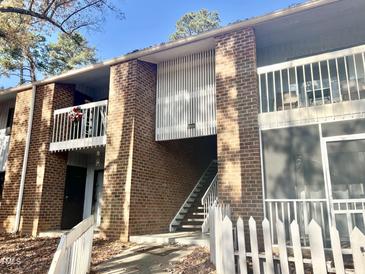 Brick condo building with stairs and small white picket fence at 1000 Sandlin Pl # B, Raleigh, NC 27606