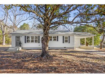 Charming white house with gray shutters, covered porch, and mature tree in front yard at 273 Pendergraft Rd, Bunnlevel, NC 28323