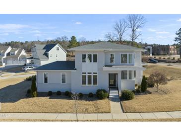 Two-story house with gray siding, multiple windows, and a landscaped yard at 235 Cottage Way, Pittsboro, NC 27312