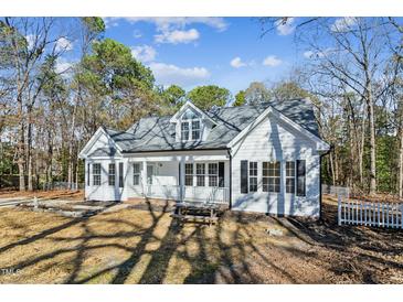 White house with gray roof, front porch, and picnic table in the yard at 309 Monterey Ct, Benson, NC 27504