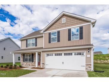 Two-story house with stone accents, a large garage, and a well-manicured lawn at 400 Azalea Gaze Dr, Youngsville, NC 27596