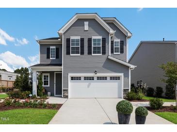 Two-story gray house with white garage door and landscaping at 601 Emerald Bay Cir, Raleigh, NC 27610