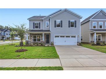 Two-story house with gray siding, stone accents, and a two-car garage at 604 Emerald Bay Cir, Raleigh, NC 27610