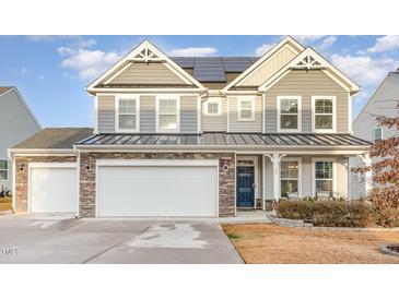 Two-story house with gray siding, stone accents, and a two-car garage at 79 Stallion Way, Benson, NC 27504