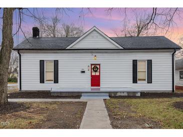 Charming white bungalow with red door, gray walkway, and well-maintained lawn at 334 E Andrews Ave, Henderson, NC 27536