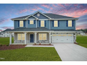 Two-story house with blue siding, stone accents, and a large front porch at 590 Glenkirk Pl, Garner, NC 27529