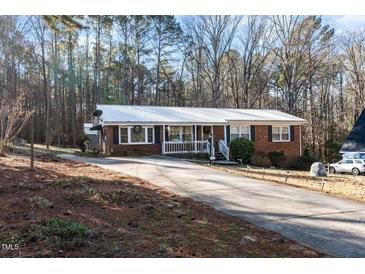 Brick ranch house with a long driveway and mature trees at 2125 Eveton Ln, Sanford, NC 27330