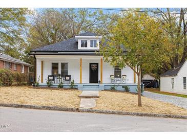 Charming white house with a gray porch, landscaping, and a black front door at 308 Cherry Grove St, Durham, NC 27703