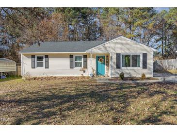 Cute ranch home with teal front door, landscaping, and spacious yard at 415 Melbourne St, Durham, NC 27703