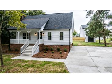 Charming one-story home with a white exterior, brick accents, and a spacious driveway at 525 Green Willow Cir, Wendell, NC 27591