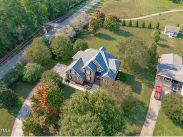 Aerial view of a two-story brick home with a large yard and circular driveway at 7601 Matherly Dr, Wake Forest, NC 27587