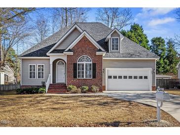 Brick and siding house with a two-car garage and well-maintained lawn at 3033 Woods Walk Way, Rocky Mount, NC 27804