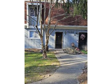 Brick front of a condo with a walkway and landscaping at 7030 Longstreet Dr # A, Raleigh, NC 27615