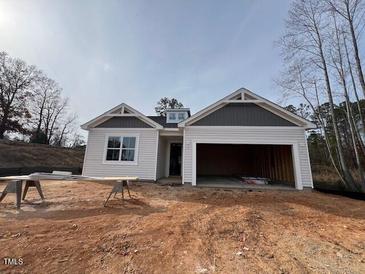 Newly constructed home with gray and white exterior, two-car garage, and partially landscaped yard at 124 Little Creek Dr, Lillington, NC 27546
